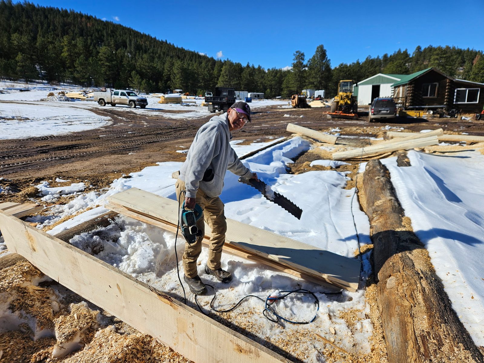 Craftsman working logs on a snowy Colorado jobsite